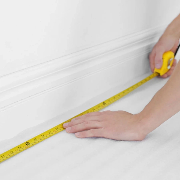 Measuring floor area for carpet tile installation.