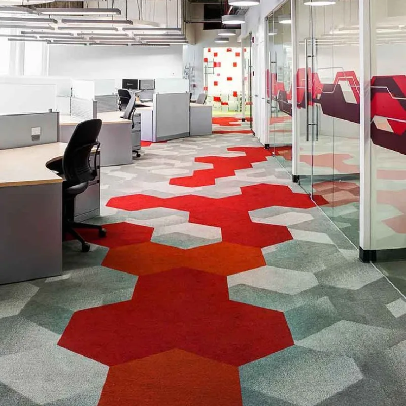 Modern hexagonal carpet tiles in red and grey for office flooring.
