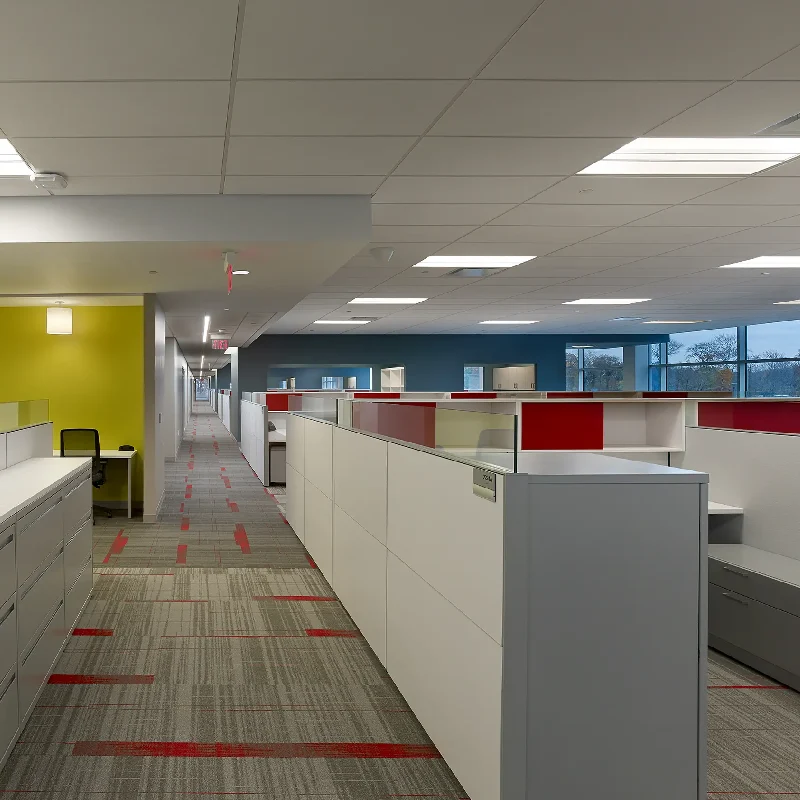 Modern linear carpet tiles with red accents in an office corridor.
