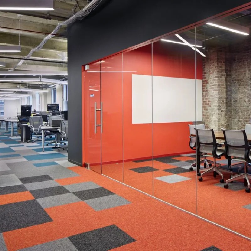Modern orange, grey, and blue checkered carpet tiles in an office.